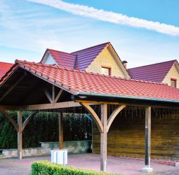 Wooden carport with red brick roof on a new house.
