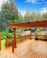 Spacious wooden deck with benches and attached pergola