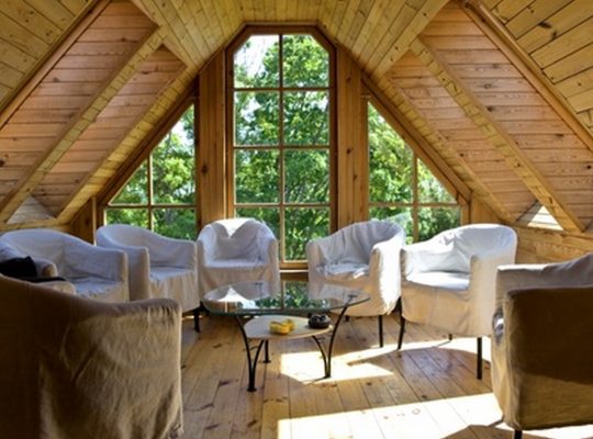 interior of mansard with glass table and white armchairs